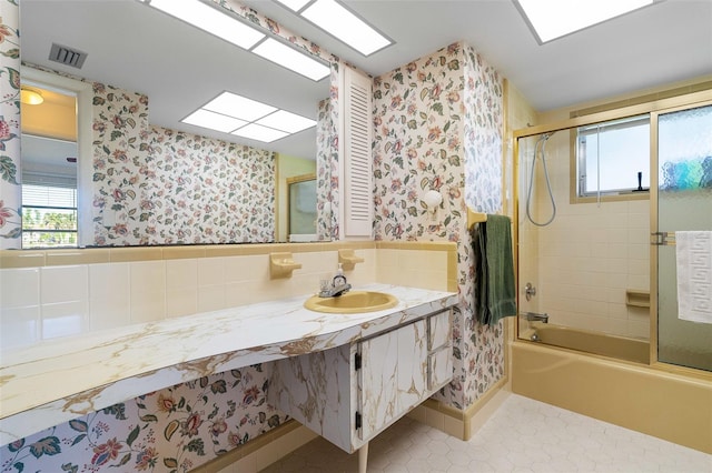 bathroom with shower / bath combination with glass door, tile patterned floors, and sink