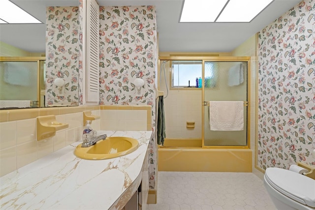 full bathroom featuring tile patterned flooring, vanity, toilet, and bath / shower combo with glass door