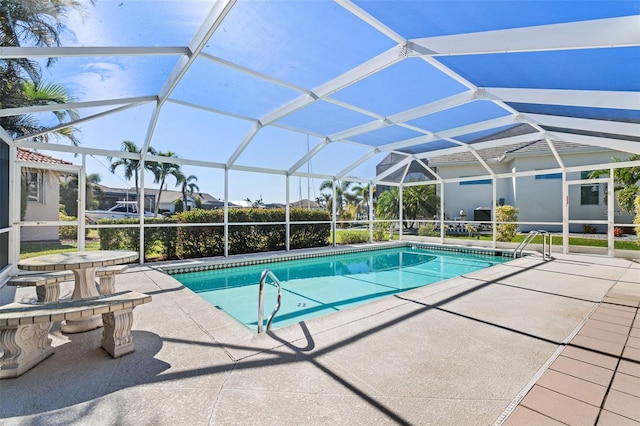 view of pool with glass enclosure and a patio area