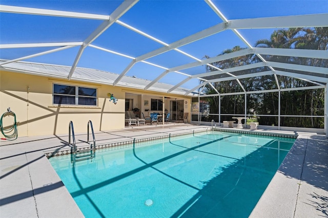 view of swimming pool featuring a lanai and a patio