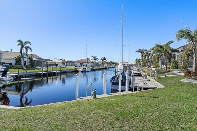 dock area with a lawn and a water view