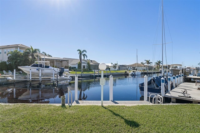 view of dock featuring a lawn and a water view