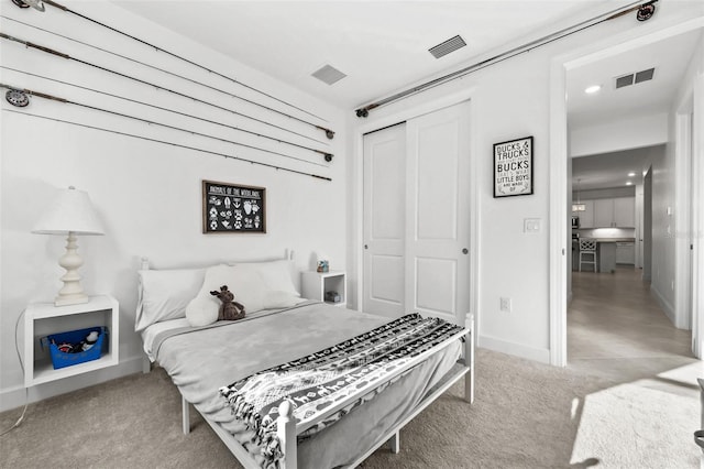 bedroom featuring light colored carpet and a closet