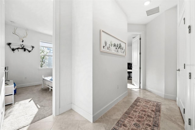 hall with light tile patterned floors