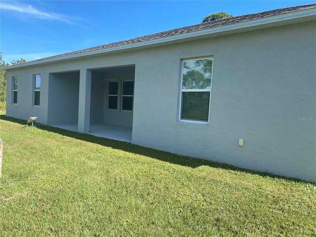 back of property featuring a lawn