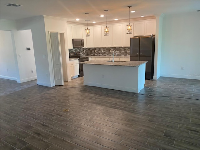 kitchen featuring sink, decorative light fixtures, a center island with sink, white cabinets, and black appliances