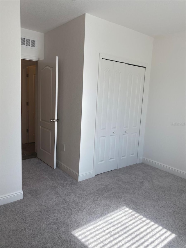 unfurnished bedroom featuring carpet flooring and a closet