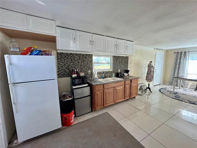 kitchen with light tile patterned flooring, sink, white refrigerator, stainless steel fridge, and backsplash