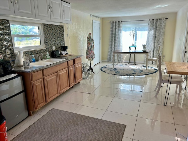 kitchen with tasteful backsplash, sink, and light tile patterned floors