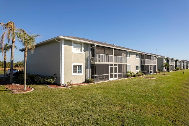 3310 Loveland Blvd Unit 2304, Punta Gorda, FL 33980 - back of house featuring stucco siding, a sunroom, and a yard