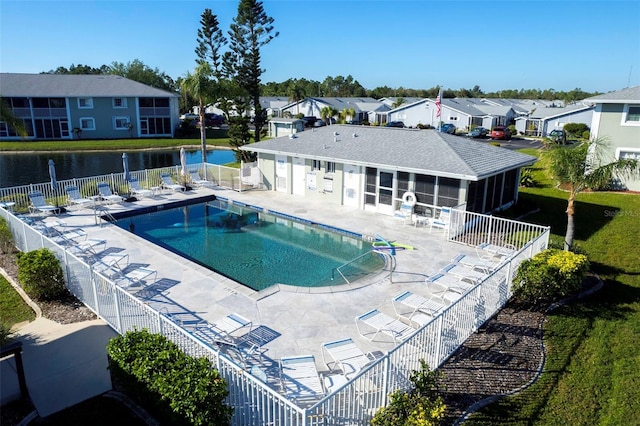 view of pool with a patio, a water view, and a sunroom