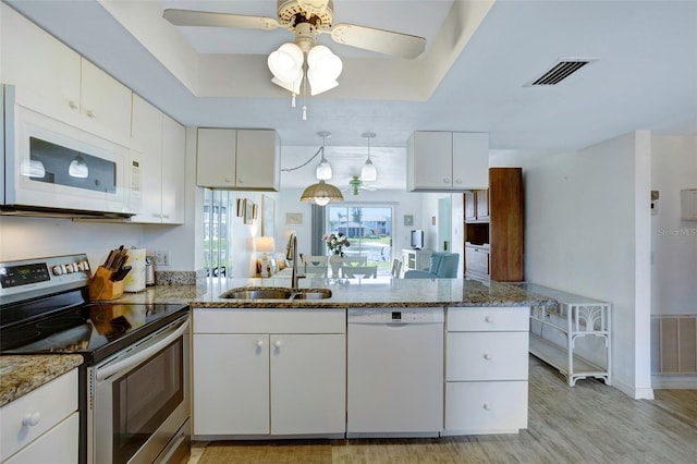 kitchen with white cabinetry, sink, kitchen peninsula, white appliances, and light wood-type flooring