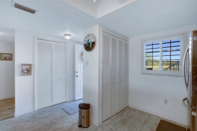 bedroom featuring light hardwood / wood-style flooring and stainless steel refrigerator