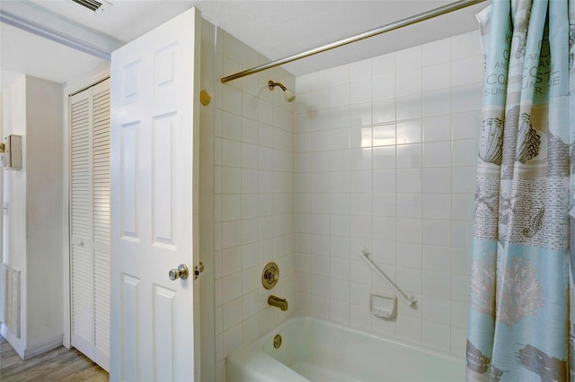 bathroom featuring wood-type flooring and shower / tub combo with curtain