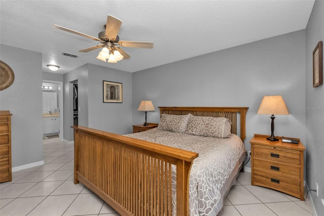 tiled bedroom featuring ceiling fan, a closet, a textured ceiling, and ensuite bath