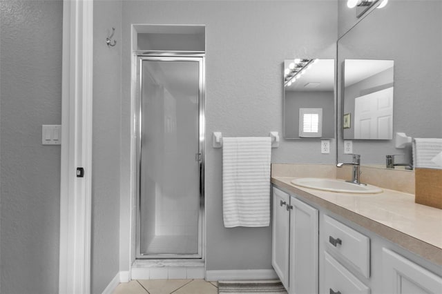 bathroom featuring tile patterned flooring, vanity, and a shower with shower door