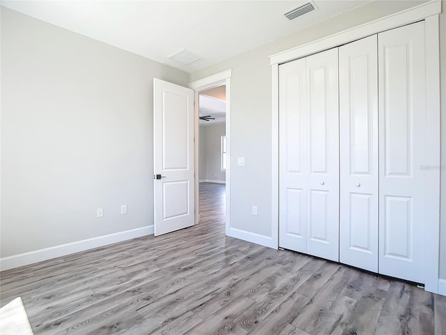 unfurnished bedroom featuring a closet and light hardwood / wood-style floors