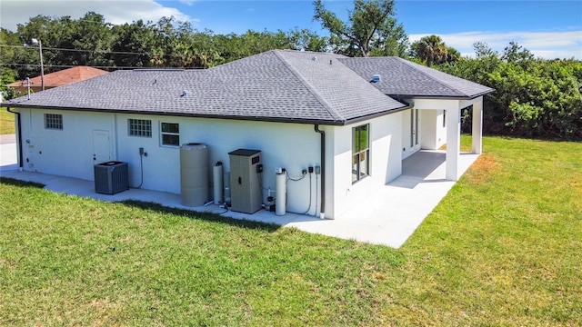 rear view of property featuring a lawn, central air condition unit, and a patio