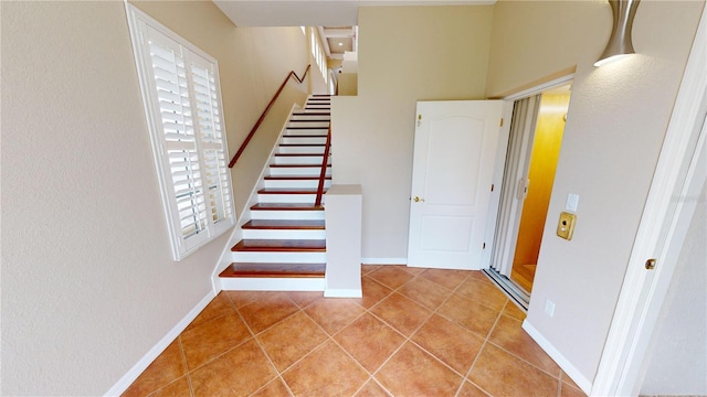 stairs with tile patterned floors and a wealth of natural light