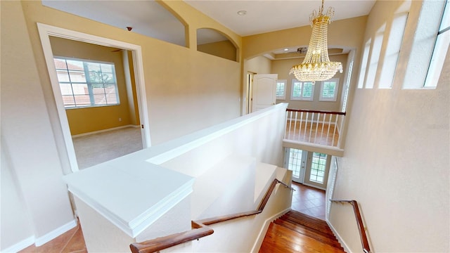 stairway with hardwood / wood-style flooring and a chandelier