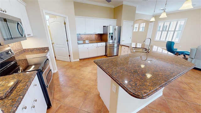 kitchen featuring white cabinets, a center island with sink, appliances with stainless steel finishes, and sink