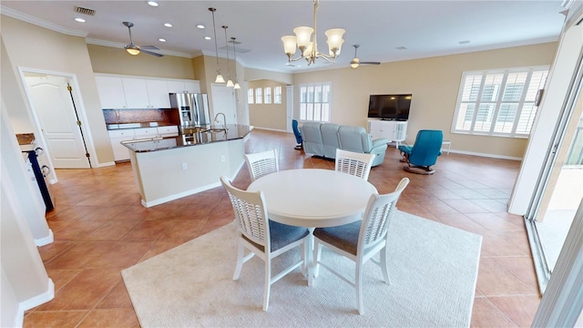 dining space featuring crown molding, light tile patterned flooring, and ceiling fan with notable chandelier