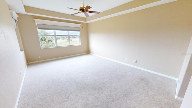 spare room with ceiling fan and light colored carpet