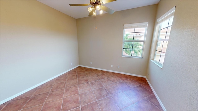 spare room with ceiling fan and light tile patterned floors