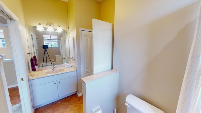 bathroom with tile patterned flooring, vanity, and toilet