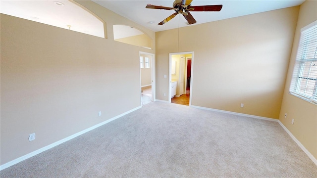 carpeted spare room with ceiling fan and lofted ceiling