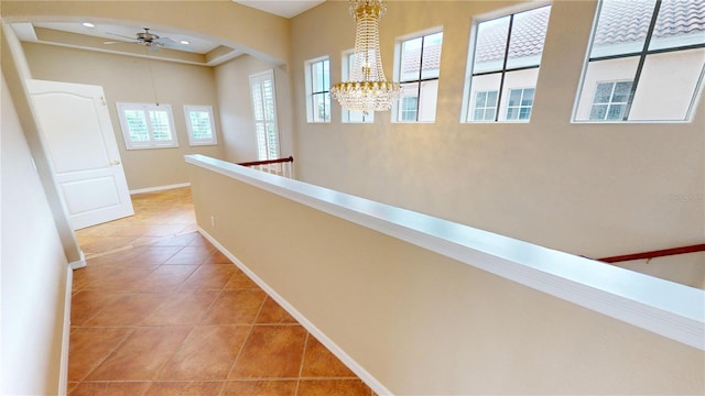 corridor featuring light tile patterned floors and a notable chandelier