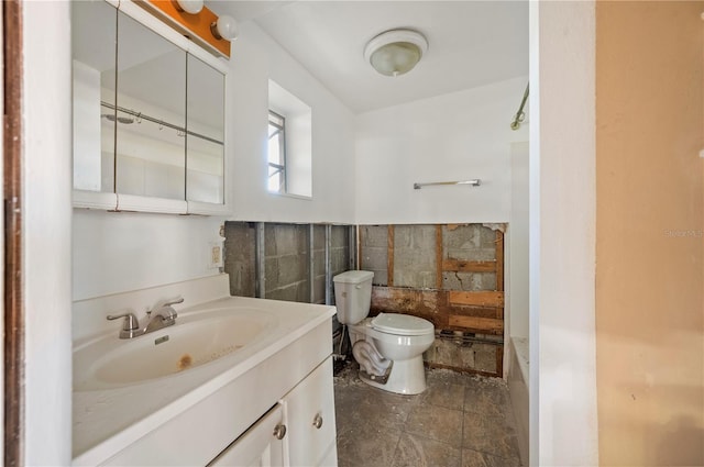 bathroom featuring vanity, tile walls, and toilet