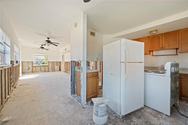 kitchen featuring washer / dryer, white refrigerator, and ceiling fan