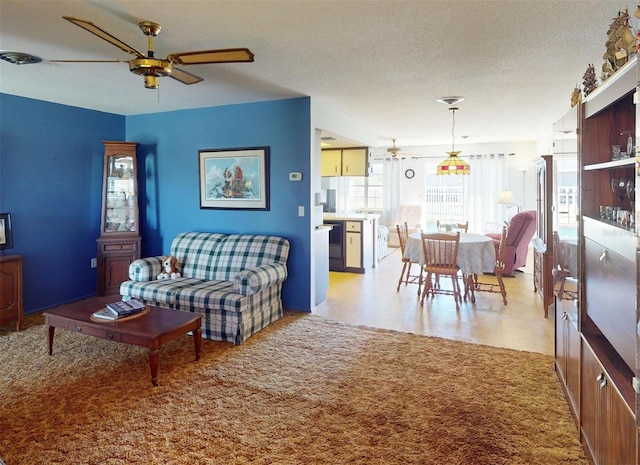 living room featuring a textured ceiling and ceiling fan