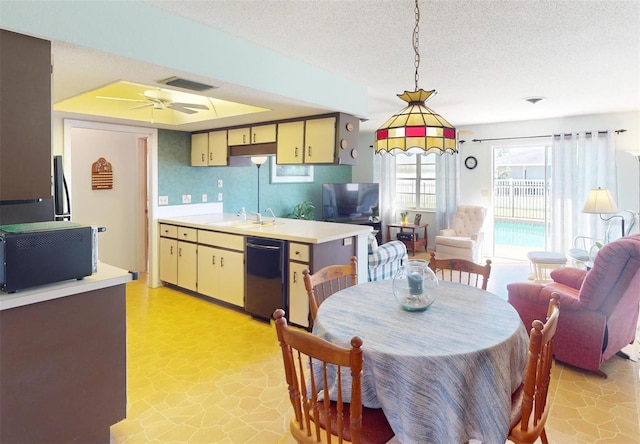 kitchen with a textured ceiling, ceiling fan, sink, black appliances, and pendant lighting