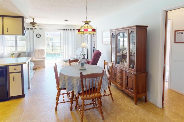 dining room with ceiling fan and a textured ceiling