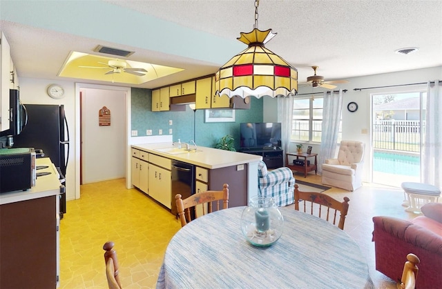 kitchen featuring black appliances, ceiling fan, sink, and hanging light fixtures