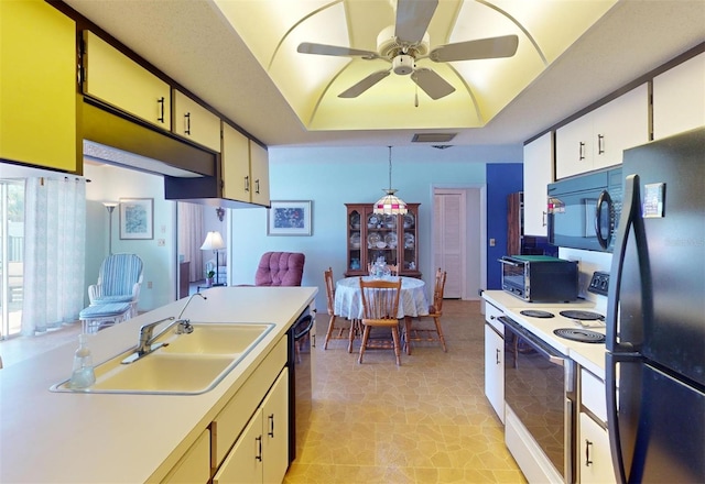 kitchen with black appliances, sink, hanging light fixtures, ceiling fan, and a tray ceiling