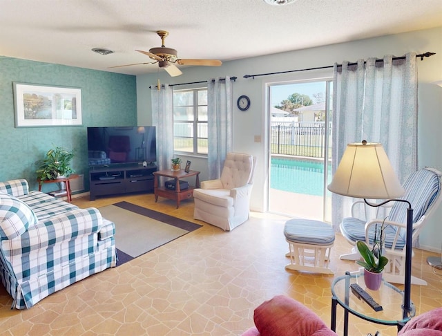 living room with a textured ceiling and ceiling fan