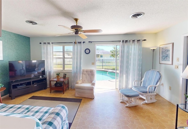 bedroom with access to outside, ceiling fan, and a textured ceiling