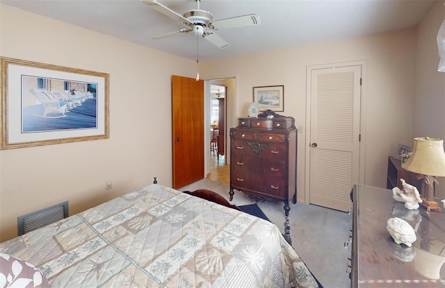 carpeted bedroom featuring ceiling fan and a closet