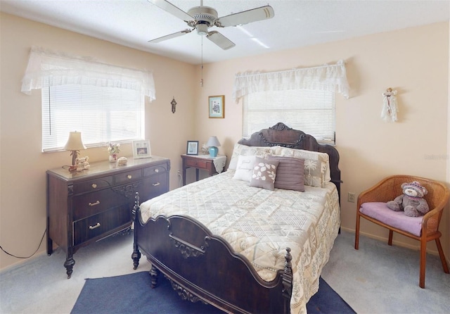 bedroom featuring multiple windows, ceiling fan, and light colored carpet