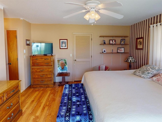 bedroom featuring ceiling fan, a closet, and light hardwood / wood-style flooring