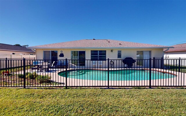 view of swimming pool featuring a yard and a patio