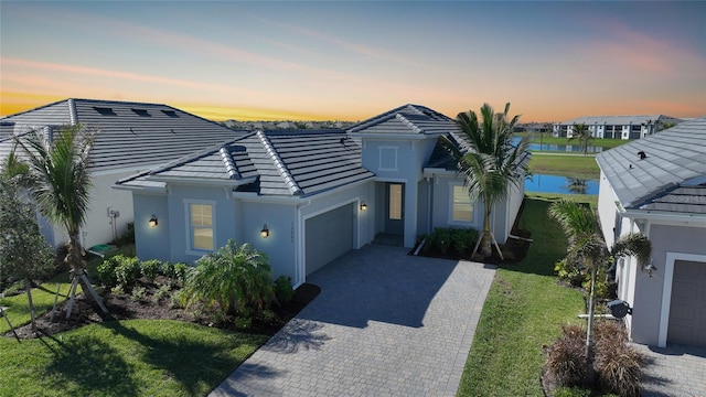 single story home featuring a garage and a lawn