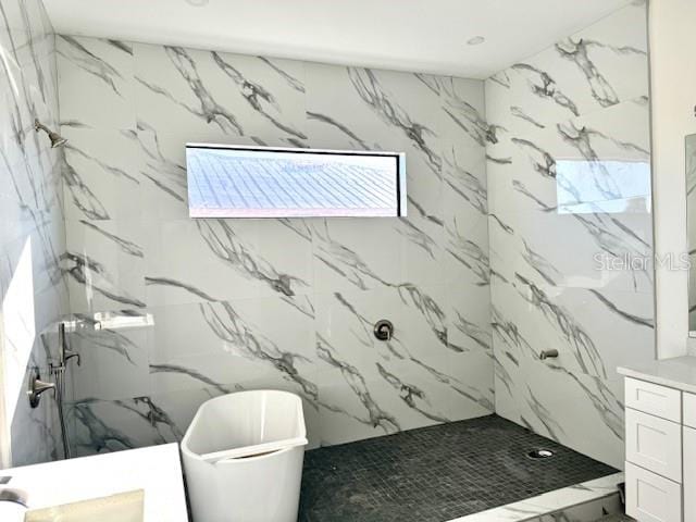 bathroom with vanity and a tile shower