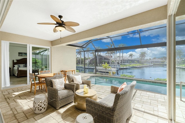 sunroom featuring ceiling fan, a swimming pool, and a water view