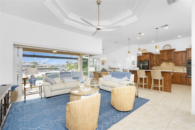 tiled living room featuring a towering ceiling, a raised ceiling, ceiling fan, and crown molding