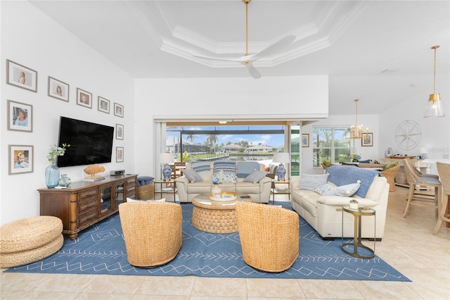 tiled living room featuring ceiling fan with notable chandelier, a raised ceiling, and ornamental molding