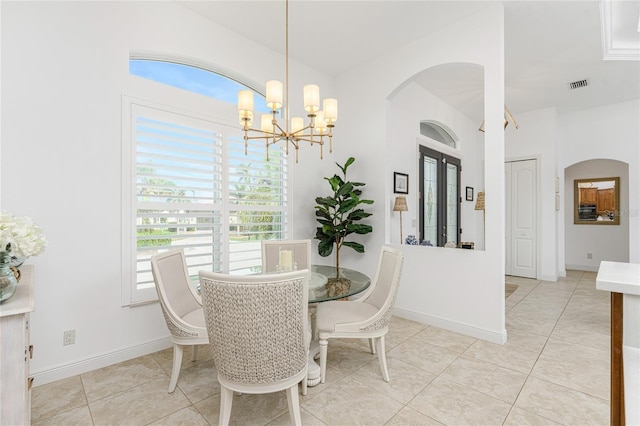 tiled dining room featuring an inviting chandelier